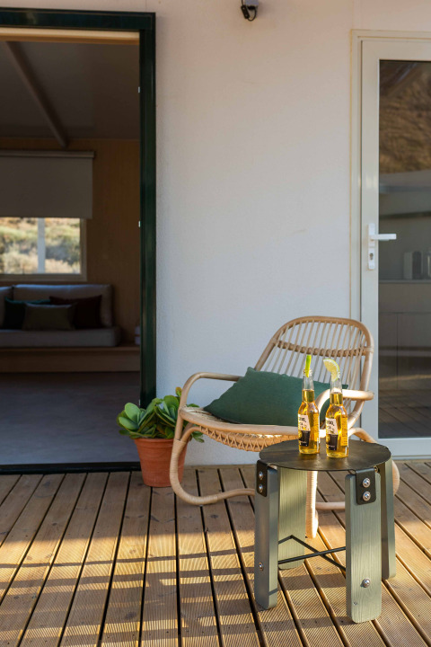 Buiten terras met stoel, groen kussen, tafeltje en twee biertjes bij Mobil Home Family, Wecamp Cabo de Gata.