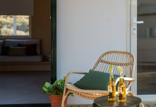 Buiten terras met stoel, groen kussen, tafeltje en twee biertjes bij Mobil Home Family, Wecamp Cabo de Gata.