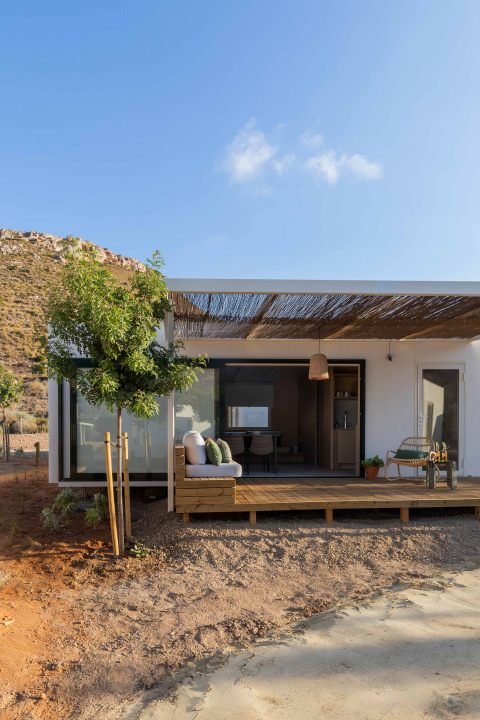 Mobil Home Family lodge bij Wecamp Cabo de Gata in Spanje, moderne houten veranda met zithoek.