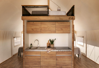 Tienda safari Glamping Family en Wecamp Cabo de Gata, España, con cocina y cama en altillo.