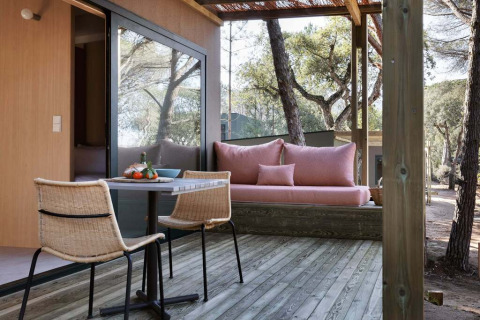 Udendørs terrasse ved Mobile home «Couple Plus» på Wecamp San Sebastián med siddepladser og skovudsigt.