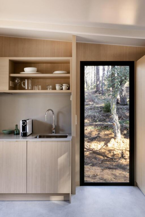 Moderne tekøkken med træskabe og vindue med udsigt til naturen i Mobile home «Couple Plus» på Wecamp San Sebastián.