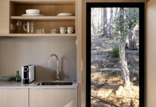 Pequeña cocina moderna con ventana al bosque en Mobile home «Couple Plus» en Wecamp San Sebastián, España.