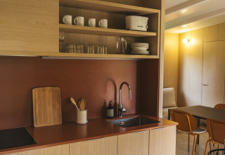 Moderne kitchenette met open houten planken bij Mobil Home Family Plus, Wecamp San Sebastián, Spanje.