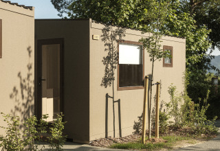 Buitenzicht op de Mobil Home Family Plus lodge met groen en bomen bij Wecamp San Sebastián, Spanje.