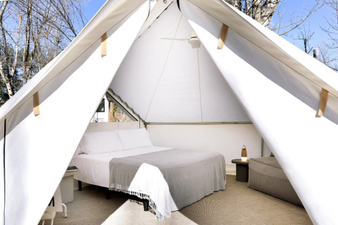 Binnenzicht van de Bell Tent bij Wecamp Santa Cristina in Spanje met een gezellig bed en moderne inrichting.