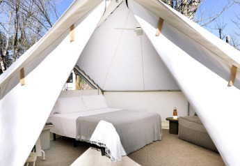 Interior view of the Bell Tent at Wecamp Santa Cristina in Spain, featuring a cozy bed and minimal decor.