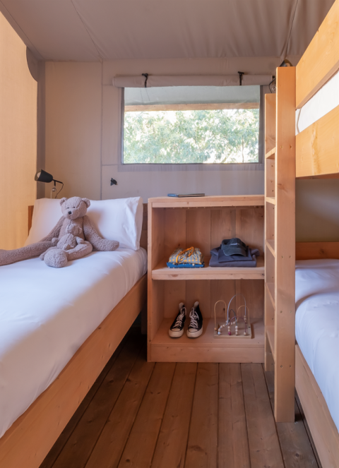 Binnenzicht van Lodge Family Plus safaritent bij Wecamp Santa Cristina met bedden en speelgoed.