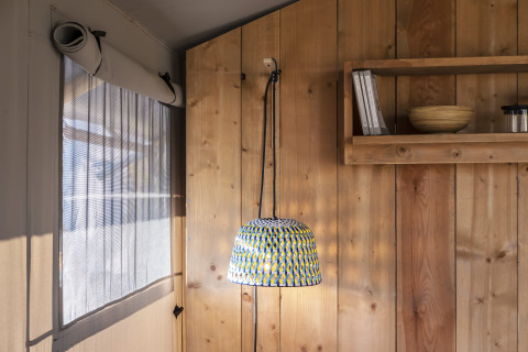 Interieur van de Lodge Family Plus safaritent in Wecamp Santa Cristina, Spanje, met een hanglamp.