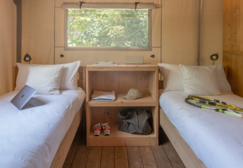 Intérieur d'une tente safari Lodge Family à Wecamp Santa Cristina en Espagne, avec deux lits simples.