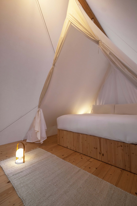 Interieur van de Cabin Tent bij Wecamp Santa Cristina in Spanje, met houten vloer en zachte verlichting.