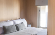 Bedroom at Mobil Home Family Plus, Wecamp Santa Cristina, Spain, featuring a cozy bed, wood paneling, and a window.