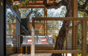 Terraza de madera con zona de asientos y árboles en Mobile Home Family de Wecamp Santa Cristina, España.