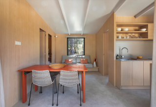 Intérieur de lodge moderne au Mobile Home Family à Wecamp Santa Cristina, Espagne, avec coin cuisine et repas.
