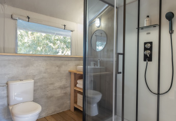 Baño moderno con suelo de madera, ducha y aseo en la Lodge Family Duplex de Wecamp Santa Cristina.