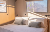 Cozy sleeping area inside the Lodge Grand Family safari tent at wecamp Santa Cristina in Spain.