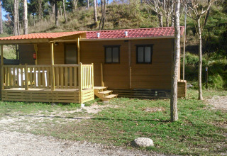 Mobile Home Basic Family au Wecamp Pedraforca en Espagne, avec terrasse en bois entourée d’arbres et nature.