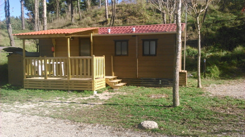 Mobilhjem Basic Family på Wecamp Pedraforca i Spanien med træterrasse og udsigt til naturlig skov.
