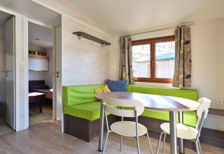 Eethoek met groene zitbank en ronde tafel in Mobile Home Basic Family+ Panoramic van Wecamp Pedraforca.