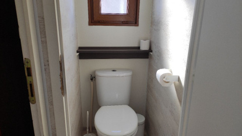 Kleine badkamer met toilet, wc-borstel en twee rollen toiletpapier bij Wecamp Pedraforca, Spanje.