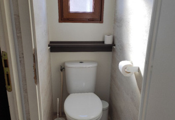 Et lille badeværelse med toilet, toiletbørste og to toiletpapirruller ved Wecamp Pedraforca i Spanien.