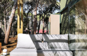 Buitenlounge met sofa en houten terras onder pergola bij Mobil Home Couple, Wecamp Pedraforca, Spanje.