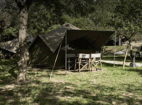 Safaritent Bell Tent bij Wecamp Pedraforca, Spanje, onder bomen en omgeven door groen gras.