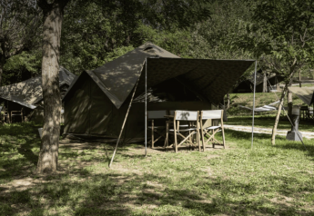 Tienda safari Bell Tent en Wecamp Pedraforca, España, rodeada de árboles y áreas verdes.