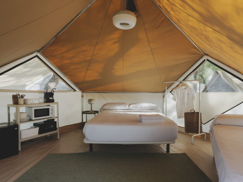 Innenausstattung eines Bell Tent Safari-Zeltes im Wecamp Jávea, Spanien, mit Bett und Regalen.