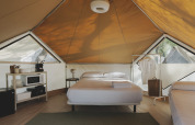 Innenausstattung eines Bell Tent Safari-Zeltes im Wecamp Jávea, Spanien, mit Bett und Regalen.