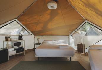 Innenausstattung eines Bell Tent Safari-Zeltes im Wecamp Jávea, Spanien, mit Bett und Regalen.