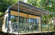 Vista exterior de la cabaña Cottage Next XL Panorama con terraza acristalada en Weekend Glamping Resort, Italia.
