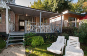 Cottage Next XL Superior moderne avec terrasse couverte et transats au Weekend Glamping Resort en Italie.