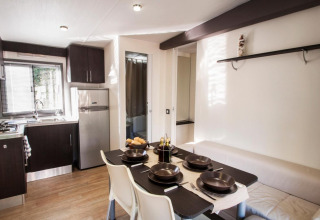 Modern kitchen and dining area in the Cottage Next XL Superior at Weekend Glamping Resort, Italy, well-lit and welcoming.