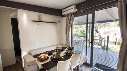 Dining area of Cottage Next XL superior at Weekend Glamping Resort in Italy, with view of the terrace outside.