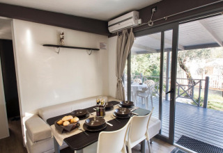 Dining area of Cottage Next XL superior at Weekend Glamping Resort in Italy, with view of the terrace outside.