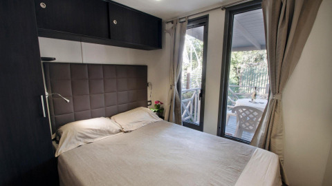 Bedroom in the Cottage Next XL Superior at Weekend Glamping Resort in Italy, featuring access to a patio.