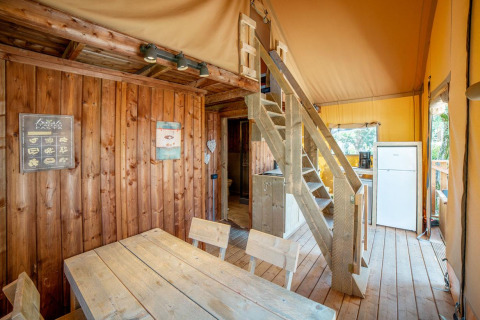 Indvendig udsigt over Safari Lodge telt på Weekend Glamping Resort i Italien med træmøbler og trappe.