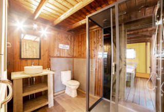 Badeværelse i Safari Lodge-safaritelte i Weekend Glamping Resort, Italien, med trævægge og moderne faciliteter.