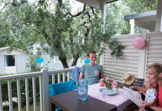 Family enjoys breakfast on the terrace at the Next L Deluxe lodge, Weekend Glamping Resort, Italy.