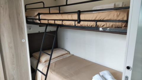 Bunk beds with beige bedding in a Next L Deluxe room at Weekend Glamping Resort in Italy.