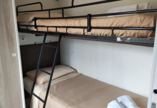 Bunk beds with beige bedding in a Next L Deluxe room at Weekend Glamping Resort in Italy.