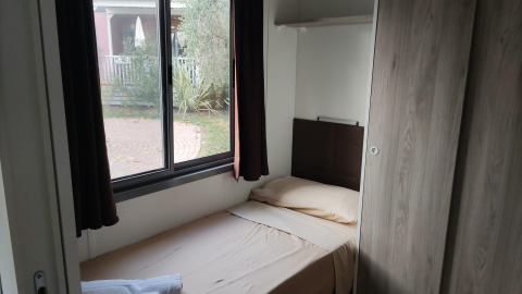 Small bedroom with single bed by the window at Next L Deluxe, Weekend Glamping Resort, Italy.
