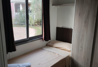 Small bedroom with single bed by the window at Next L Deluxe, Weekend Glamping Resort, Italy.