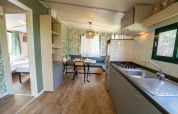 Vue intérieure du Cottage Classic au Weekend Glamping Resort en Italie, avec cuisine et espace repas.