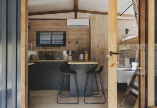 Interieur van TINY HOME FAMILY bij Wecamp Jávea, Spanje met keuken, eethoek en stapelbed in beeld.