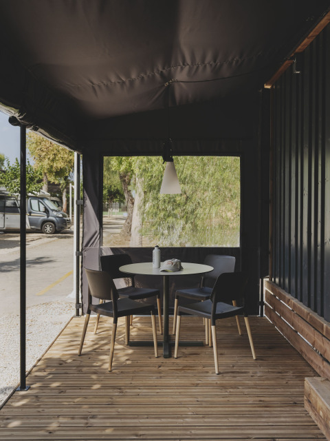 Buiten terras met ronde tafel en vier stoelen bij Tiny Home Family in Wecamp Jávea, Spanje.