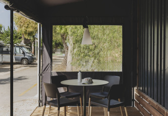 Buitenterras met ronde tafel en vier stoelen bij Tiny Home Family in Wecamp Jávea, Spanje.