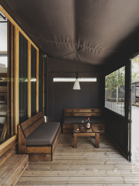 Sfeervol houten terras met banken bij TINY HOME FAMILY, Wecamp Jávea, Spanje.