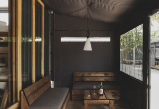 Sfeervol houten terras met banken bij TINY HOME FAMILY, Wecamp Jávea, Spanje.